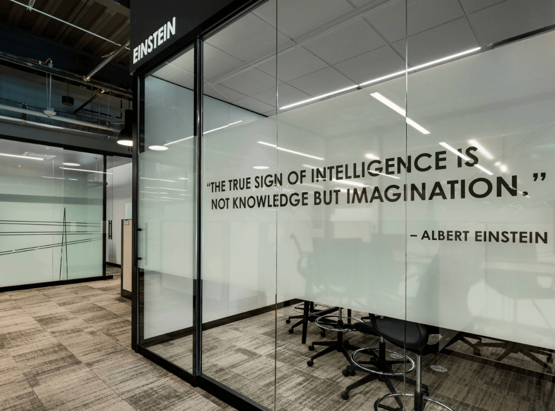 A large strip of frosted window film with custom printed inspiration quote applied to conference room glass walls