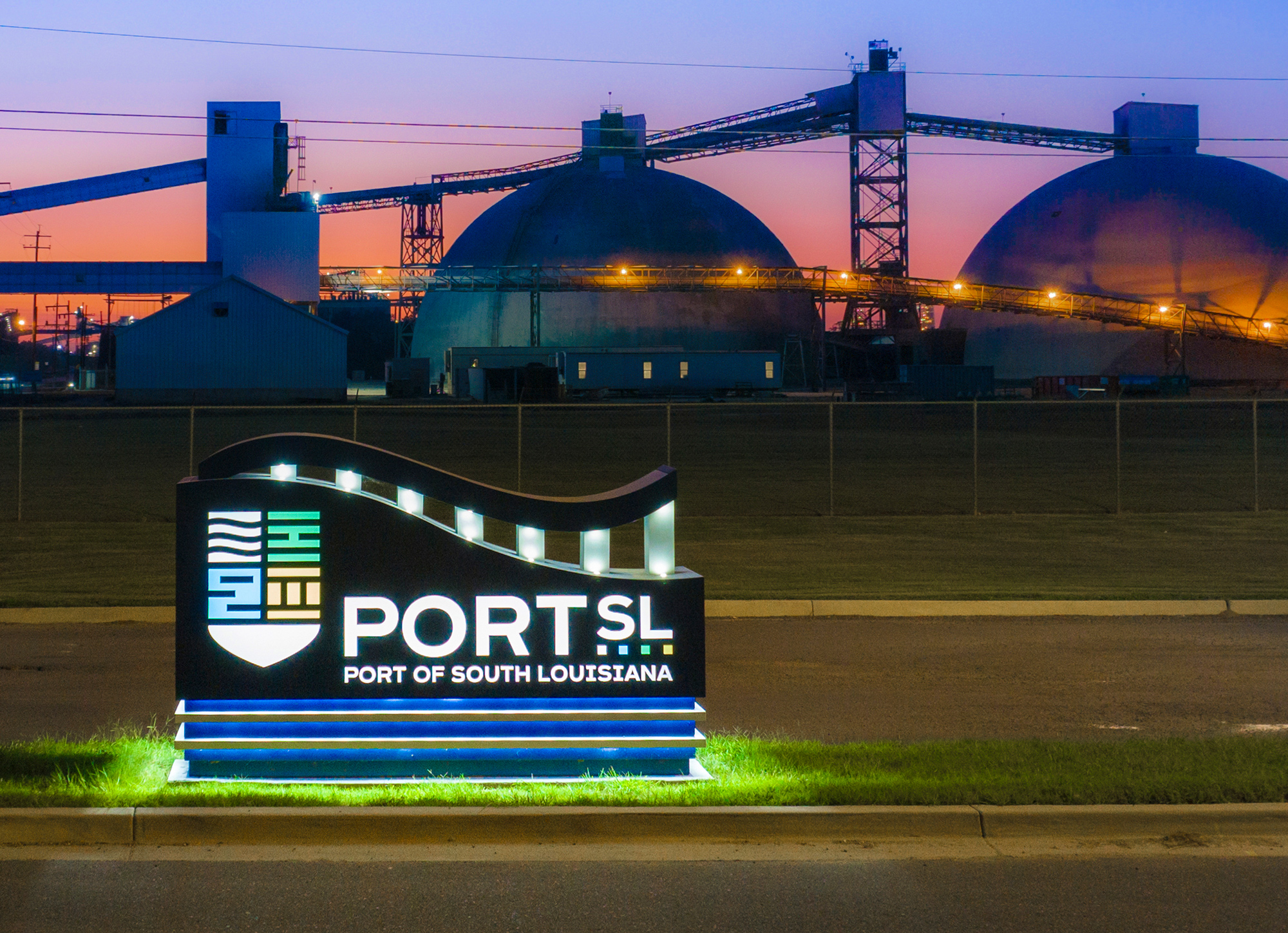 A twilight photo of an illuminated exterior monument sign marking the entrance of the Port of South Louisiana