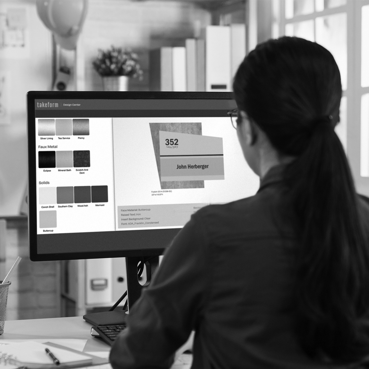 Designer at their desk designing a sign in Takeform's Design Center