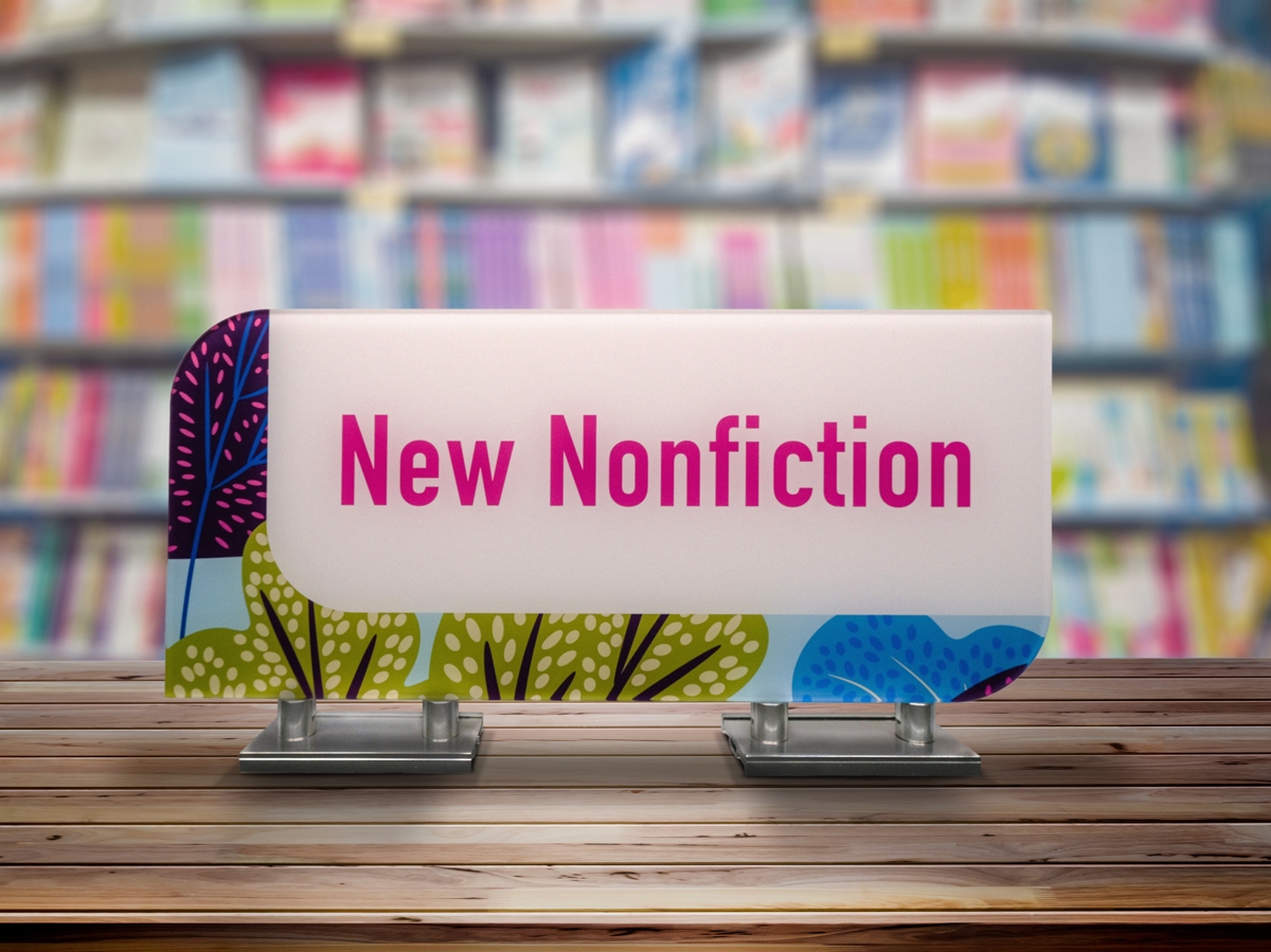 A freestanding section identifier sign on a library shelf demonstrates deep offering with over 150 sign types.