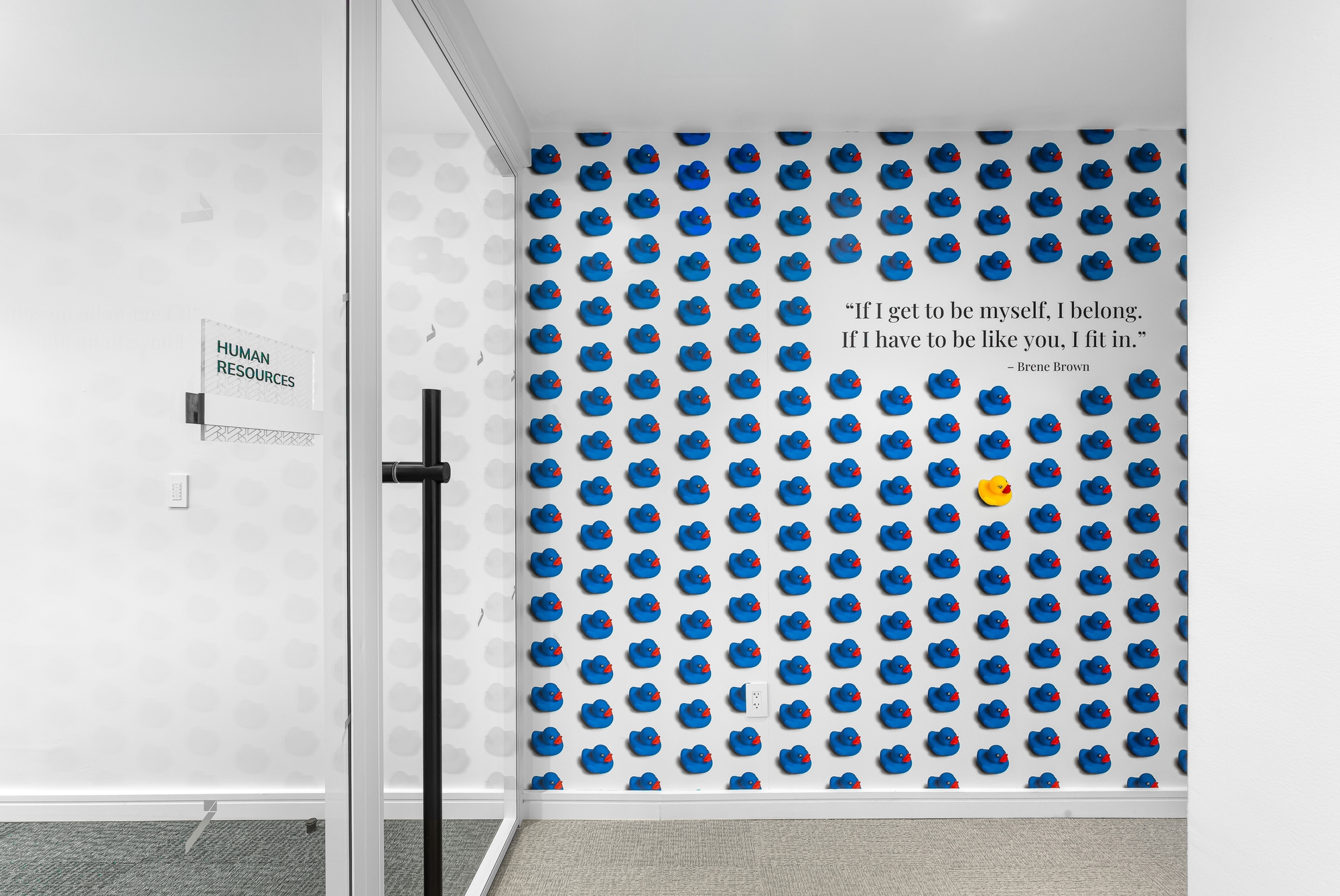 Experiential graphics and interior signage in a workplace setting featuring custom wallcovering with a full-color branded photo.